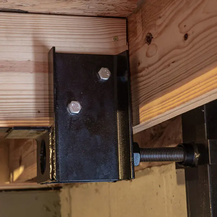 A close-up view of a black and red electrical component, likely a Pfisterer RSC-T rail connector or a similar force arrester, with six brass-colored cylindrical terminals visible on the top.