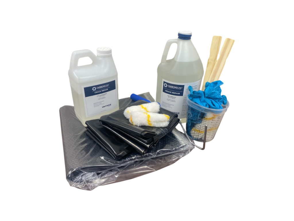 Carbon fiber wall brace kit components, including two jugs of Carbonbond Crack Repair epoxy, black carbon fiber fabric, a measuring cup with blue gloves, wooden mixing sticks, and a small roller.