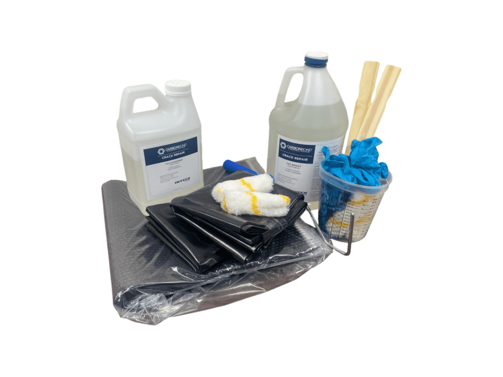 Carbon fiber wall brace kit components, including two jugs of Carbonbond Crack Repair epoxy, black carbon fiber fabric, a measuring cup with blue gloves, wooden mixing sticks, and a small roller.